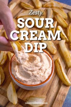 a person dipping some food into a bowl on a wooden cutting board with the words zesty sour cream dip above it