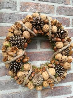 a wreath made out of pine cones and acorns hanging on a brick wall