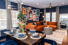 a living room filled with furniture next to a dining room table and chairs in front of a large window