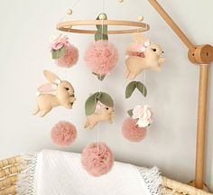 a baby crib with pink pom poms hanging from it's sides