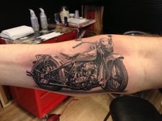 a man's arm with a motorcycle tattoo on it