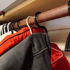 a rack with clothes hanging on it next to a coat hanger and an umbrella