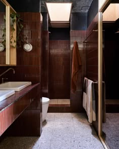 a bathroom with a toilet, sink and shower stall in the middle of it's tiled floor