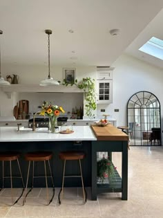 a large kitchen with an island and bar stools