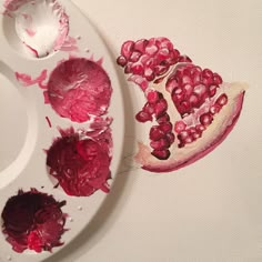 a white plate topped with pomegranates on top of a table