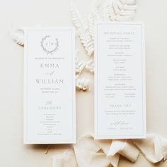 two wedding program cards on top of each other next to some white flowers and leaves