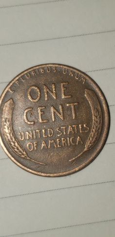 an old one cent united states of america coin on lined paper with lines in the background