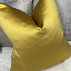 a yellow pillow sitting on top of a bed