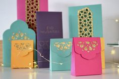 five different colored cards with gold foil designs on them, all lined up against each other