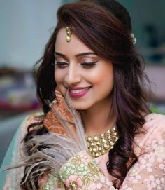 a woman with long hair wearing a pink dress and gold jewelry is smiling at the camera