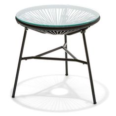 a round glass table with black metal legs and an iron frame on the top, against a white background