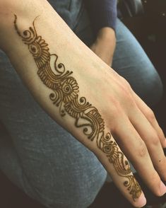 a woman's hand with a henna tattoo on it