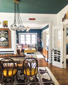 a dining room table with yellow chairs in front of it