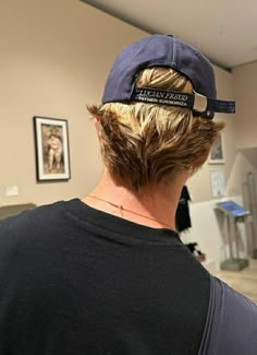 the back of a person's head wearing a hat with an inscription on it