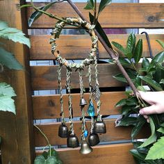 a person holding a tree branch with bells hanging from it