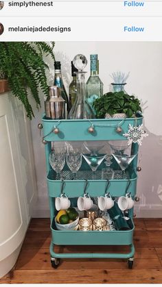 a blue cart filled with lots of dishes and drinks on top of a wooden floor