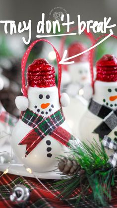 snowmen with hats, scarfs and scarves are sitting in front of pine cones