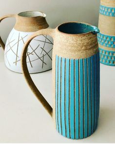 three ceramic mugs sitting next to each other on top of a white countertop