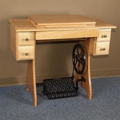 an old fashioned sewing machine sits on the floor next to a wooden desk with drawers