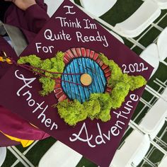 a purple graduation cap with an image of a blue door and green plants on it