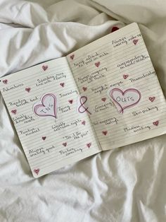 two notebooks with writing on them sitting on a bed