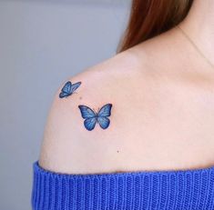 a woman's shoulder with two blue butterflies on it