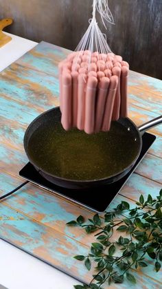 a bunch of hot dogs are being cooked in a frying pan on a table