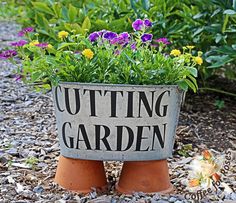 a potted planter with purple and yellow flowers in it sitting on the ground