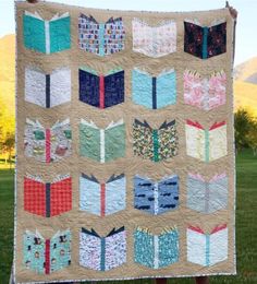 a quilted wall hanging on the side of a grass covered field