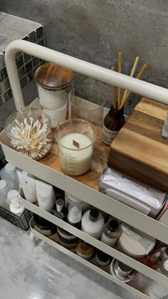 a shelf filled with lots of different types of beauty products and candles on top of it