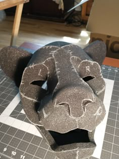 an animal head made out of cement sitting on top of a cutting board