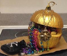 a gold pumpkin decorated with beads and jewelry