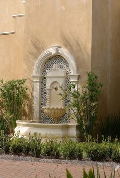 a fountain in front of a tan building