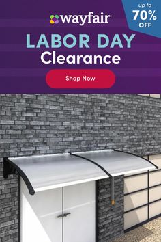 an advertisement for labor day clearance on the side of a building with brick wall and garage doors