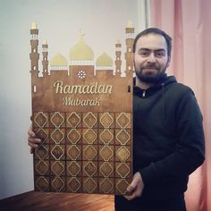 a man holding up a sign that says ramadan mubarak in front of him