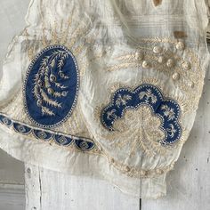 an old blue and white purse hanging on a wall