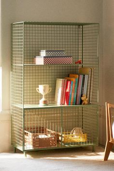 a green shelf with books and other items on it