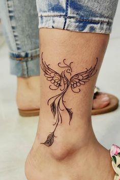 a woman's foot with a tattoo design on the side of her leg and an arrow