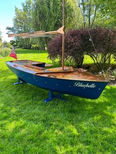 a blue boat sitting on top of a lush green field