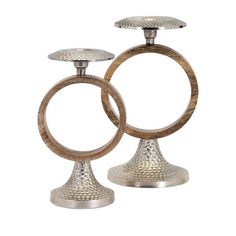 two metal candlesticks sitting on top of each other