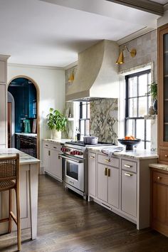 a kitchen with an oven, stove and dining room table in the background on a hard wood floor