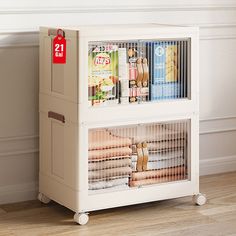 a magazine rack with magazines in it on the floor next to a white wall and wooden floors