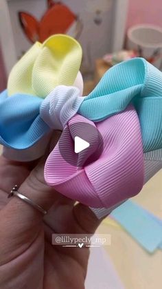 two small bows are being held in someone's hand, one is blue and the other is pink