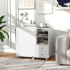 a living room with white furniture and pictures on the wall