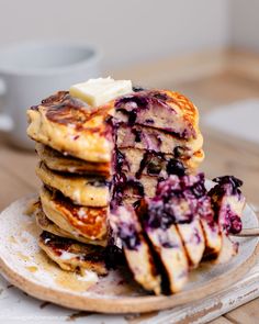 a stack of pancakes with blueberries and butter on top