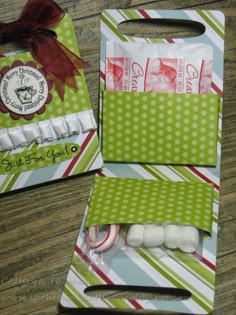 two green and white paper bags with candy in them