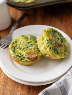 two egg muffins on a plate with a fork