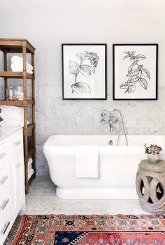 a white bath tub sitting under two framed pictures