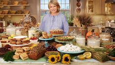 a woman standing in front of a table full of food