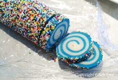 two blue and white lollipops with sprinkles sitting on plastic